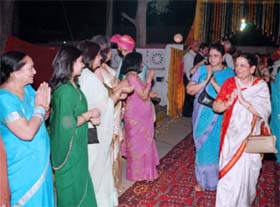 the bride's family welcomes the groom's family showering 'akshat', rose petals and 'itra'.